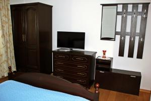 a bedroom with a bed and a dresser with a television at Pensiunea Crimar in Ilteu +18 photos