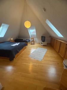 a attic bedroom with two beds and a television at Strandgut in Fehmarn