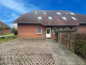 a red brick house with a white door at Strandgut in Fehmarn