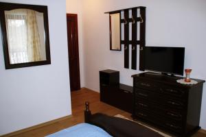 a living room with a tv and a dresser at Pensiunea Crimar in Ilteu