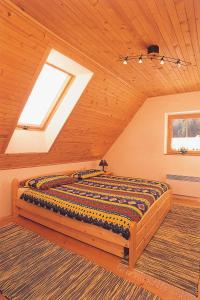 a bedroom with a large bed in a attic at Horská chata Stará Horáreň 1 in Dobšiná