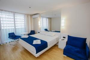 a bedroom with a bed and two blue chairs at Batumi Bay Retreat in Batumi +34 photos