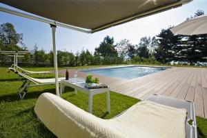 a patio with a table and chairs and a pool at Villa Il Portico in Verbania