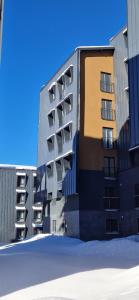 a tall building with snow in front of it at Apartman Mali princ Jahorina in Jahorina