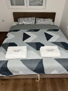 a bed with two white towels on top of it at Downtown Apartment in Strumica