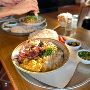 a table with a bowl of food on a table at Hotel Shoshana - Adults Only in Eilat