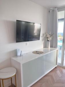 a white desk with a tv on a wall at SARA RIVIERA Costa Plana in Cap d'Ail