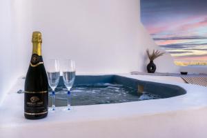 a bottle of champagne and two wine glasses on a table at Filippa Studios in Plaka