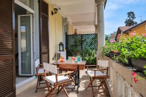 a patio with a table and chairs on a balcony at Casa Miralago in Castelveccana