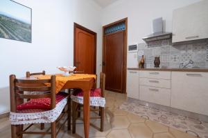 a kitchen with a wooden table and chairs and a sink at Domus61 in Marsala +5 photos