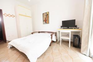 a bedroom with a bed and a desk with a computer at Domus61 in Marsala