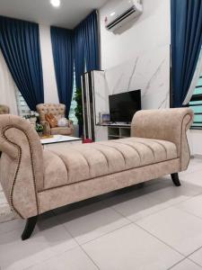 a living room with a couch and a television at Cik Yam Homestay Pool, Melaka l For Malay Only in Melaka