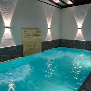 a large pool of blue water in a room with lights at Cik Yam Homestay Pool, Melaka l For Malay Only in Melaka