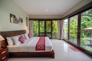 a bedroom with a bed and large windows at Mardika Private Villa Ubud in Ubud