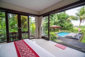 a bedroom with a bed and a view of a pool at Mardika Private Villa Ubud in Ubud