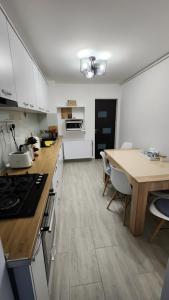 a kitchen with white cabinets and a wooden counter top at Retreat Apartment in Tîrgu Ocna