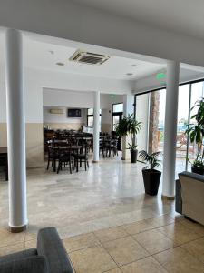 a dining room with tables and chairs in a building at New York Plaza Hotel Apartments in Paphos