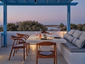 a table and chairs on a patio with a couch at Casa Stellino in Naousa