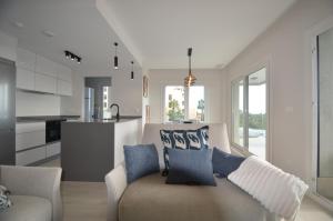 a living room with a couch and a kitchen at Los Camaleones EXCELLENT & SOLMARES in Isla Canela