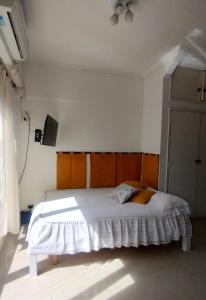 a bedroom with a bed with a wooden headboard at monoambiente Gascón in Mar del Plata