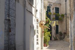 eine Gasse in einer Altstadt mit Topfpflanzen in der Unterkunft GEOMETRIC BLUE in Casamassima