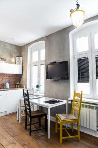 a kitchen with a table and chairs and a tv at Loft Rooms - centrum - bezpłatny parking in Ełk