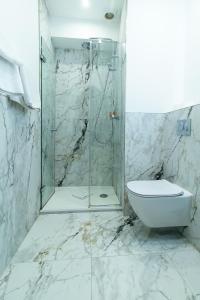 a bathroom with a glass shower and a toilet at Hotel des Bains in Paris +26 photos