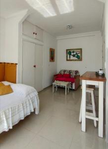 a bedroom with a bed and a desk and a table at monoambiente Gascón in Mar del Plata