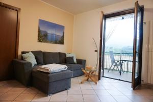 a living room with a couch and a balcony at Residenza La Rocca in Castello Valsolda
