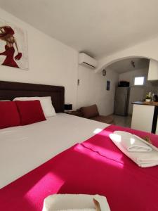 une chambre avec un grand lit avec une couverture rose dans l'établissement Apartments Iris, à Vir