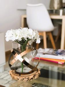 un vaso pieno di fiori bianchi su un tavolo di A Xanela do Salnés a Ribadumia