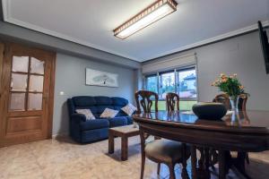 ein Wohnzimmer mit einem Tisch und einem blauen Sofa in der Unterkunft Ca'Gloria in El Valle