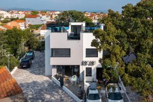 una vista aerea di un edificio bianco con auto parcheggiate di Villa Vida a Vodice