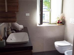 a bathroom with a white toilet and a window at Innesti Rooms&Apartments - Gli Appartamenti in Pergine Valsugana +31 photos