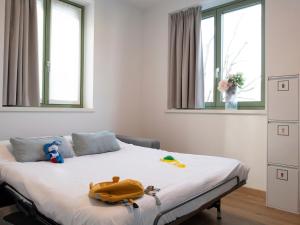 a bedroom with a bed with a yellow bag on it at Innesti Rooms&Apartments - Gli Appartamenti in Pergine Valsugana