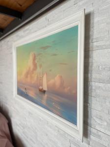 a painting of a sailboat on the ocean on a wall at Elena Casa Turistica in Padova +17 photos