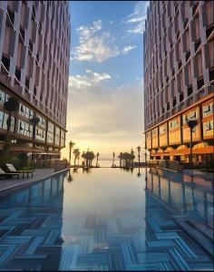 an image of two buildings with a pool between them at Mandala Chambayy Mũi Né TNRSS in Mui Ne
