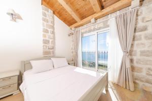 佩特罗瓦纳莫鲁Olive Resort & Villas的卧室里有一张白色的床和一扇大窗户