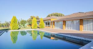 una casa con piscina frente a ella en El Toril Glamping Experience, en Parrillas