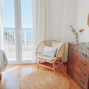 krzesło z poduszką w pokoju z oknem w obiekcie KALAMIES - Secluded Beach Apartments w mieście Skála Kefalonias