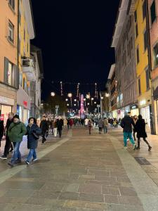a group of people walking down a street at night at Rota's House III in Bergamo