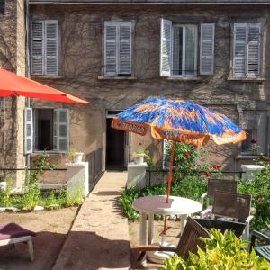 un tavolo con un ombrellone davanti a un edificio di Studio confort à Néris-les-Bains - 18 m² avec jardin a Néris-les-Bains Altre 15 foto