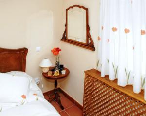 1 dormitorio con cama y mesa con espejo en Welcoming house in Ávila with private parking, en Ávila