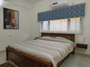 a bedroom with a bed and a window with a air conditioner at Best 2x3BHK Premium Homestay - Emerald, 7 Elysee Homestay in Trichūr