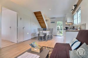 a living room with a table and a kitchen at Ty gwenn in Cancale