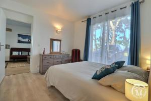 a bedroom with a large bed and a window at Ty gwenn in Cancale