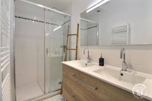 a bathroom with a glass shower and a sink at Ty gwenn in Cancale