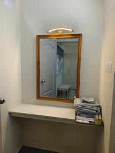 a mirror on a shelf in a bathroom at Best 2x3BHK Premium Homestay - Emerald, 7 Elysee Homestay in Trichūr +27 photos