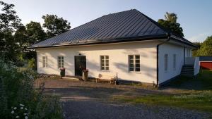 a small white house with a black roof at Bjärkas Golf & Country Club in Nivelax