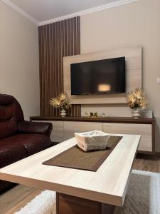 Una sala de estar con televisión y una mesa de café. en Vila Jovanovic, en Bajina Bašta 19 fotos más